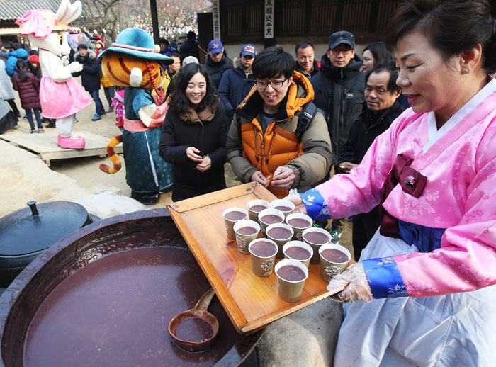 offering patjuk to people in a cultural event (Source: Korea.Net)