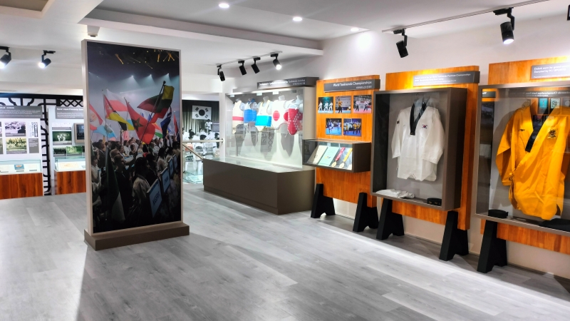 The exhibition showcases the evolution of Taekwondo uniforms and protective equipment throughout its history. 