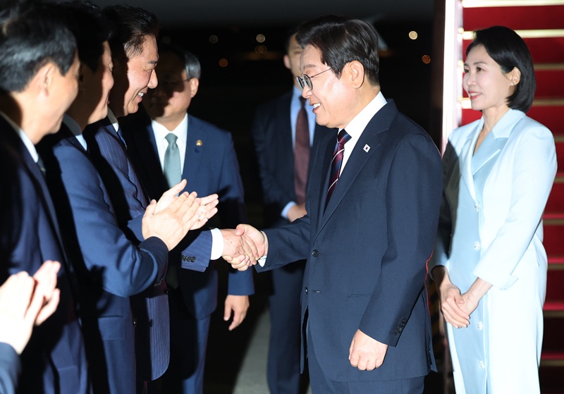 President Lee Jae-myung (second from right) on June 19 is greeted by Kim Byung-kee, floor leader of the ruling Democratic Party of Korea, and other well-wishers after arriving at Seoul Air Base in Seongnam, Gyeonggi-do Province. (Yonhap News)  