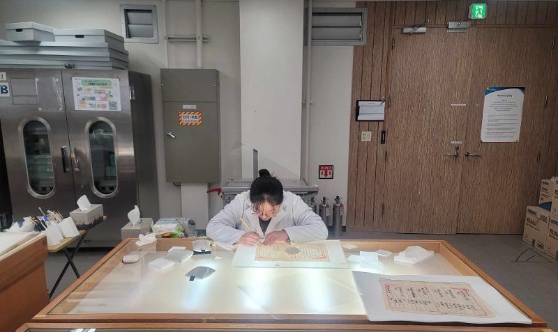 A researcher on Jan. 7 works on restoring the Archives of the Donghak Peasant Revolution, which are designated UNESCO World Heritage, at the restoration room of the Seongnam, Gyeonggi-do Province, branch of the National Archives of Korea. (Yoo Yeon Gyeong)