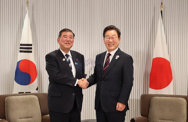 President Lee Jae-myung (right) on June 17 poses for photos with Japanese Prime Minister Shigeru Ishiba at the Group of Seven Summit in Kananaskis of Canada's Alberta province. 
